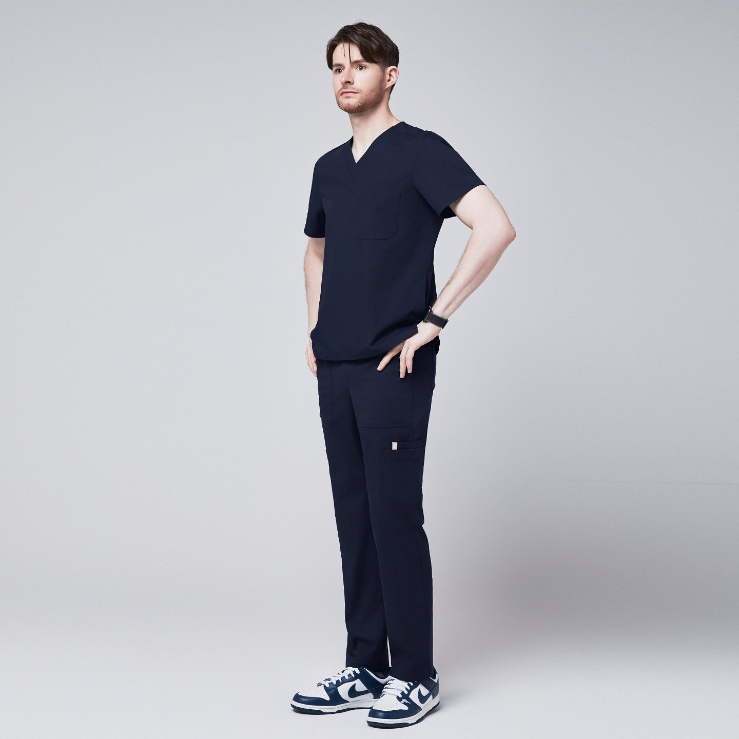 Close-up of Zenir navy 8-pocket straight scrub pants paired with blue and white sneakers,Navy