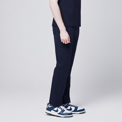 Image of Close-up of Zenir navy 8-pocket straight scrub pants paired with blue and white sneakers,Navy