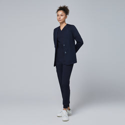 Image of Professional woman modeling a navy comfort cardigan paired with a V-neck scrub top and jogger-style scrub pants, complemented by white sneakers,Navy