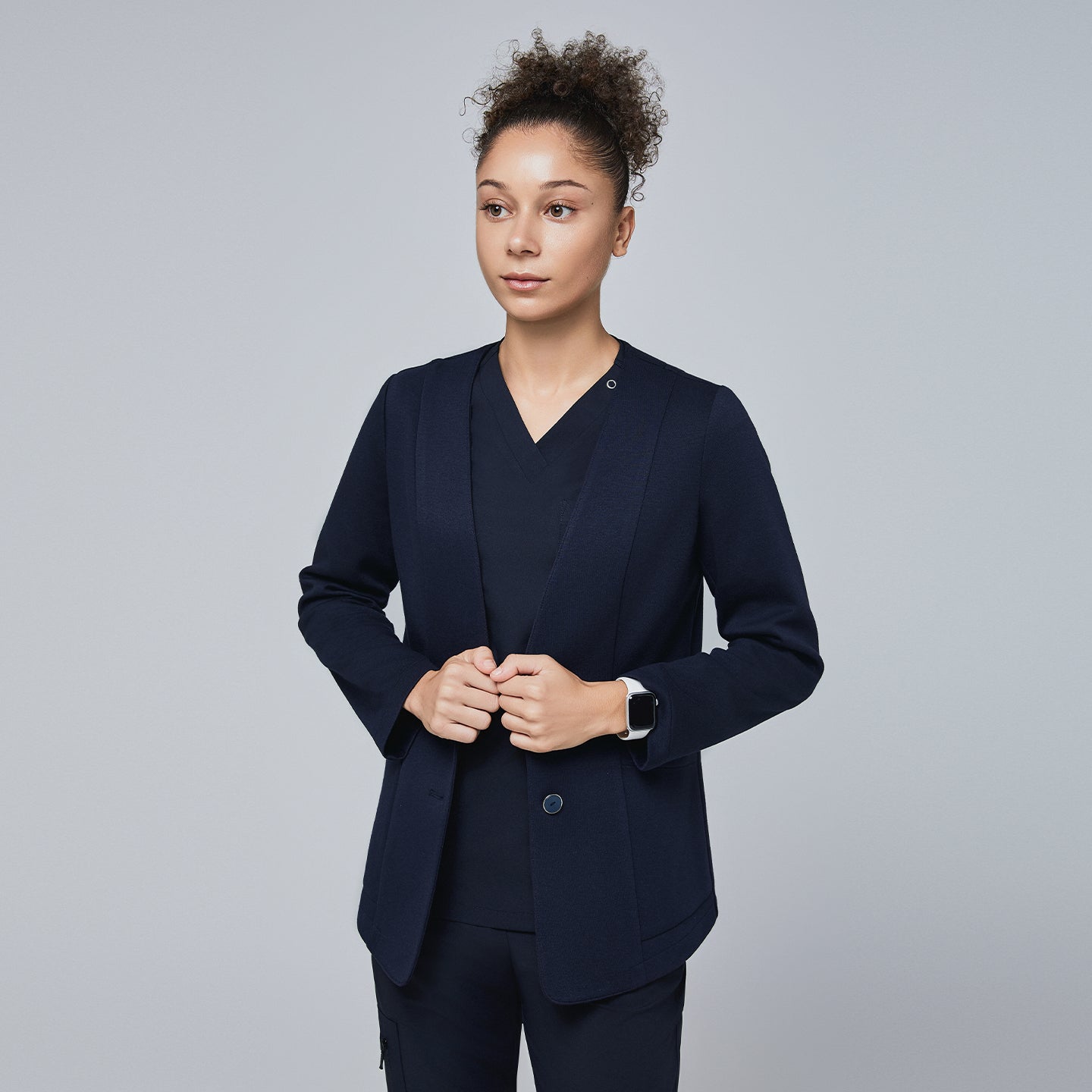 Close-up of a woman wearing a navy comfort cardigan over a matching V-neck scrub top, styled for a polished and professional look,Navy