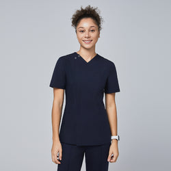 Image of Female model wearing a navy V-neck scrub top with a subtle front zipper, short sleeves, chest pocket, and a fitted design, standing and smiling,Eco Navy