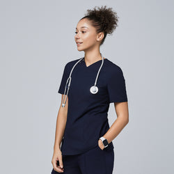 Image of Female model wearing a navy V-neck scrub top with a front zipper, chest pocket, and short sleeves, accessorized with a stethoscope around her neck, smiling and looking to the side,Eco Navy