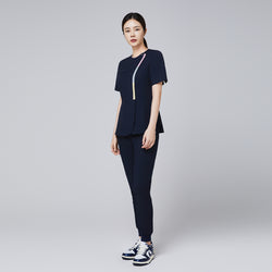 Image of Full-body view of a woman wearing a navy scrub set with gradient zipper detail, paired with athletic sneakers,Navy