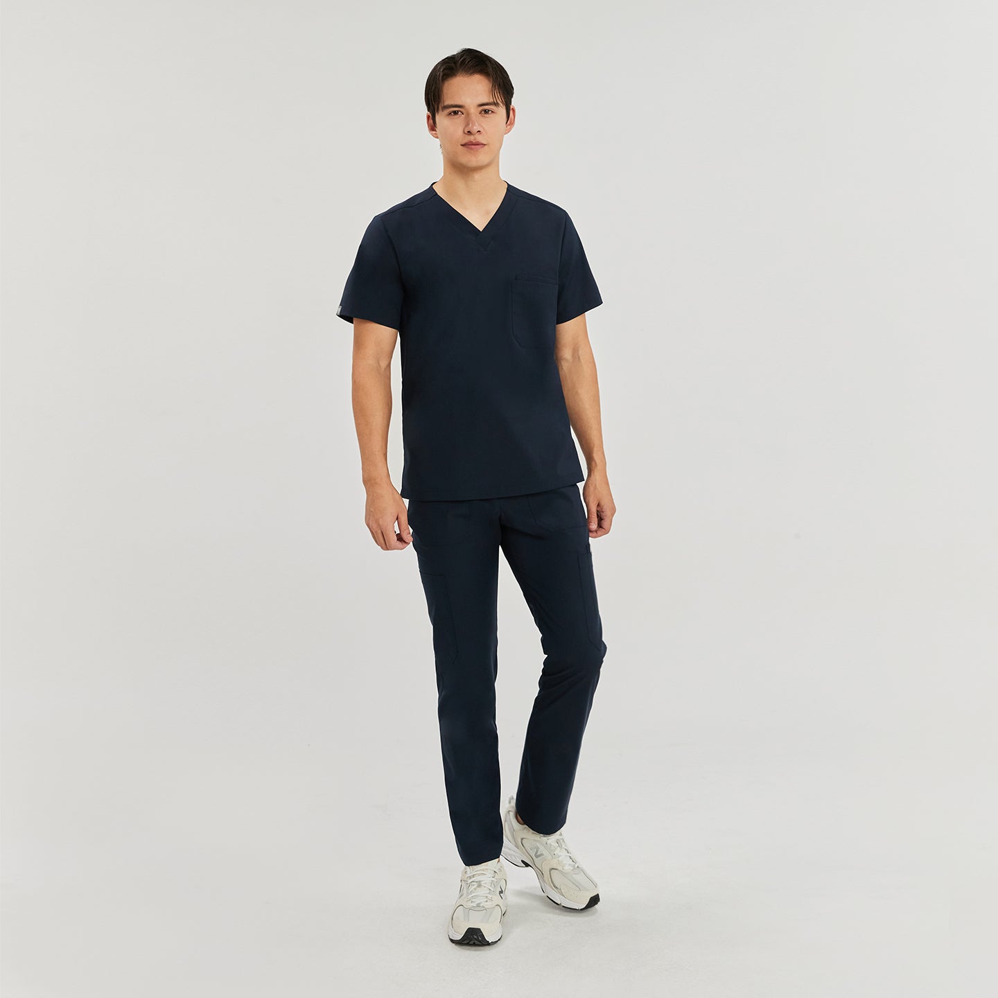  Full-body front view of a model in navy blue zipper straight scrub pants with zipper details and a matching top, wearing light-colored sneakers,Navy