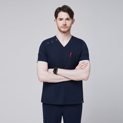 Image of Man standing confidently in a navy scrub top with button detailing on the shoulders, showcasing a red pen in the chest pocket for a professional and practical look,Eco Navy