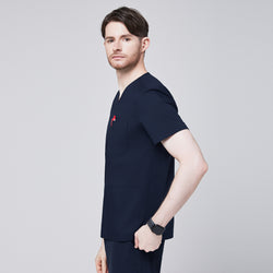 Image of Side profile of a man wearing a navy scrub top with shoulder button detailing, showcasing a sleek and modern design with a red pen in the chest pocket,Eco Navy