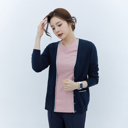 Woman wearing a navy soft touch cardigan over a pink top and navy pants, looking down and touching her hair, with a smartwatch on her wrist,Navy
