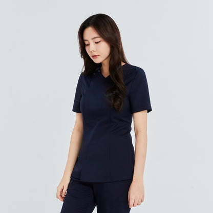  Woman in a navy front zipper scrub top with matching straight-leg pants, standing sideways with her head slightly bowed,Navy