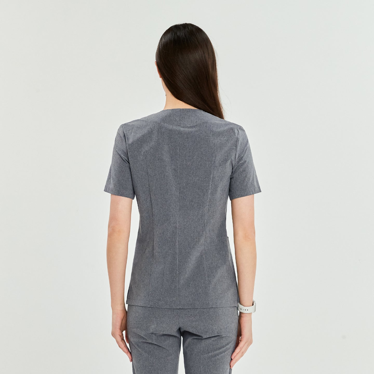 Back view of a woman wearing a soft gray Zenir front zipper scrub top and matching pants,Soft Gray
