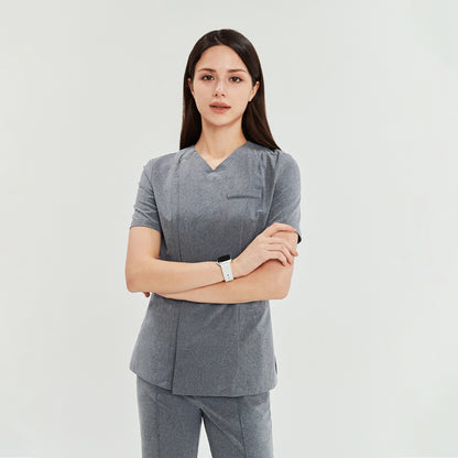 Woman in soft gray Zenir front zipper scrub top and tapered pants, standing with arms crossed,Soft Gray