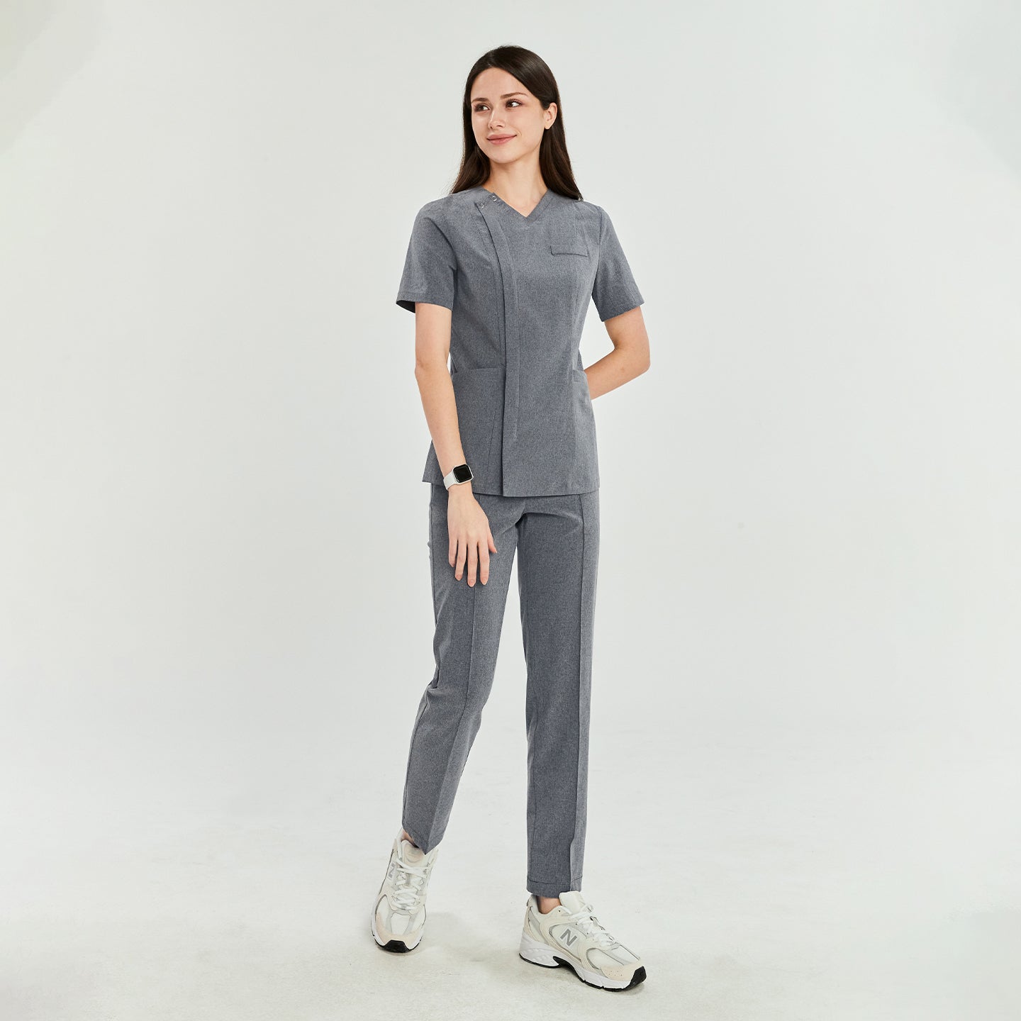 Woman in soft gray Zenir front zipper scrub top with matching pants, standing side view. Professional and comfortable fit,Soft Gray