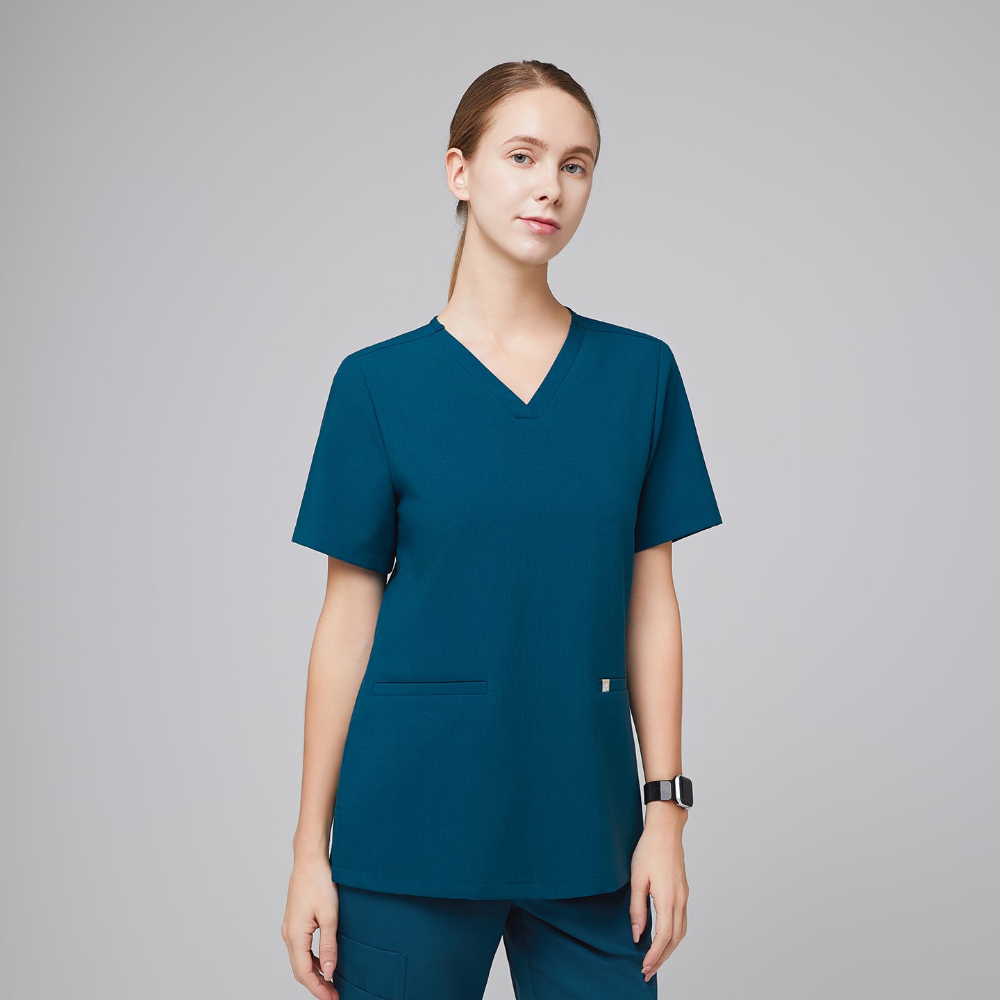 Model wearing an ocean teal double pocket scrub top with matching scrub pants,Ocean Teal