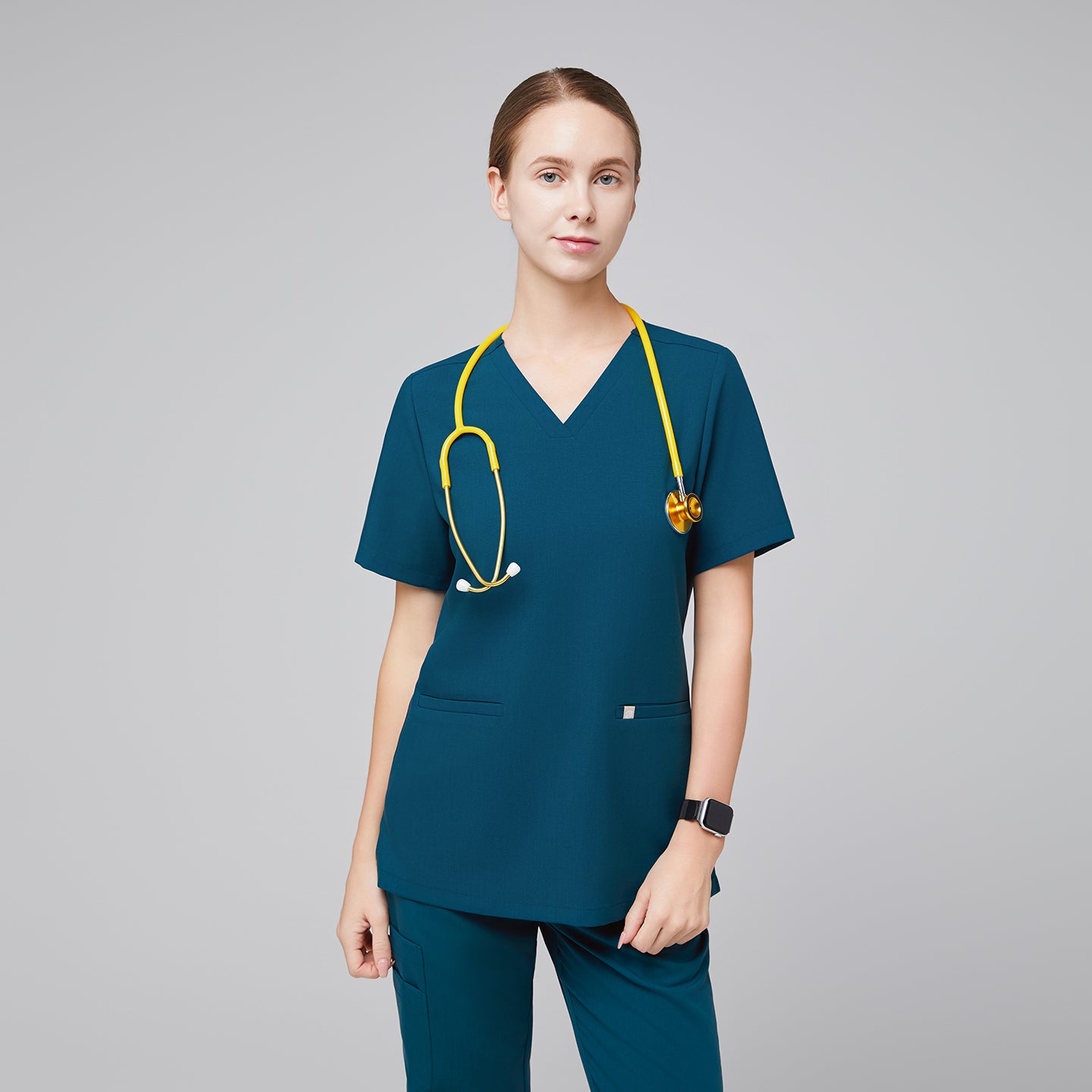 Model wearing an ocean teal double pocket scrub top with a yellow stethoscope and matching scrub pants,Ocean Teal