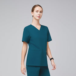 Image of A woman wearing an Ocean Teal Double Pocket Scrub Top with short sleeves,Ocean Teal