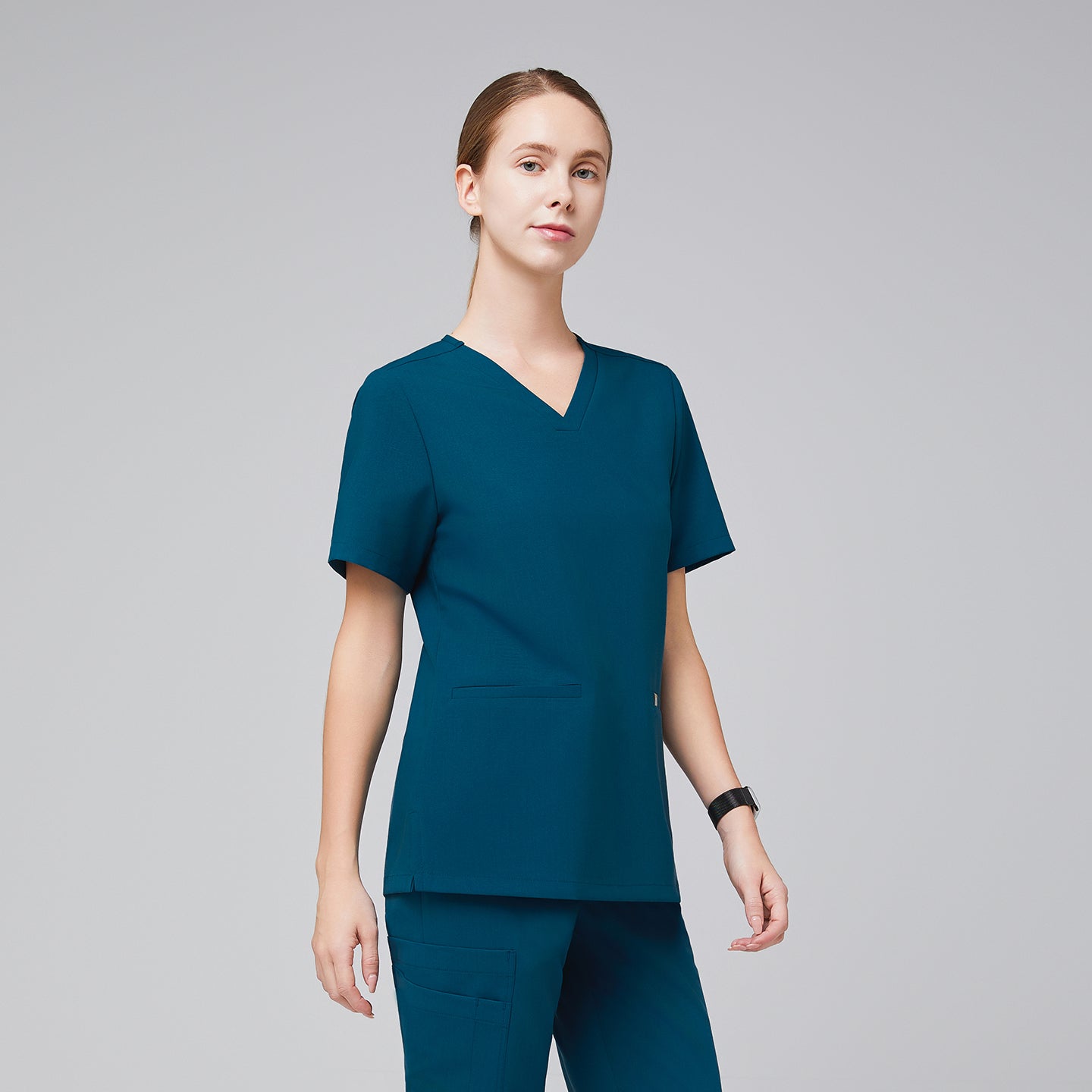 Model wearing an ocean teal double pocket scrub top with matching scrub pants,Ocean Teal