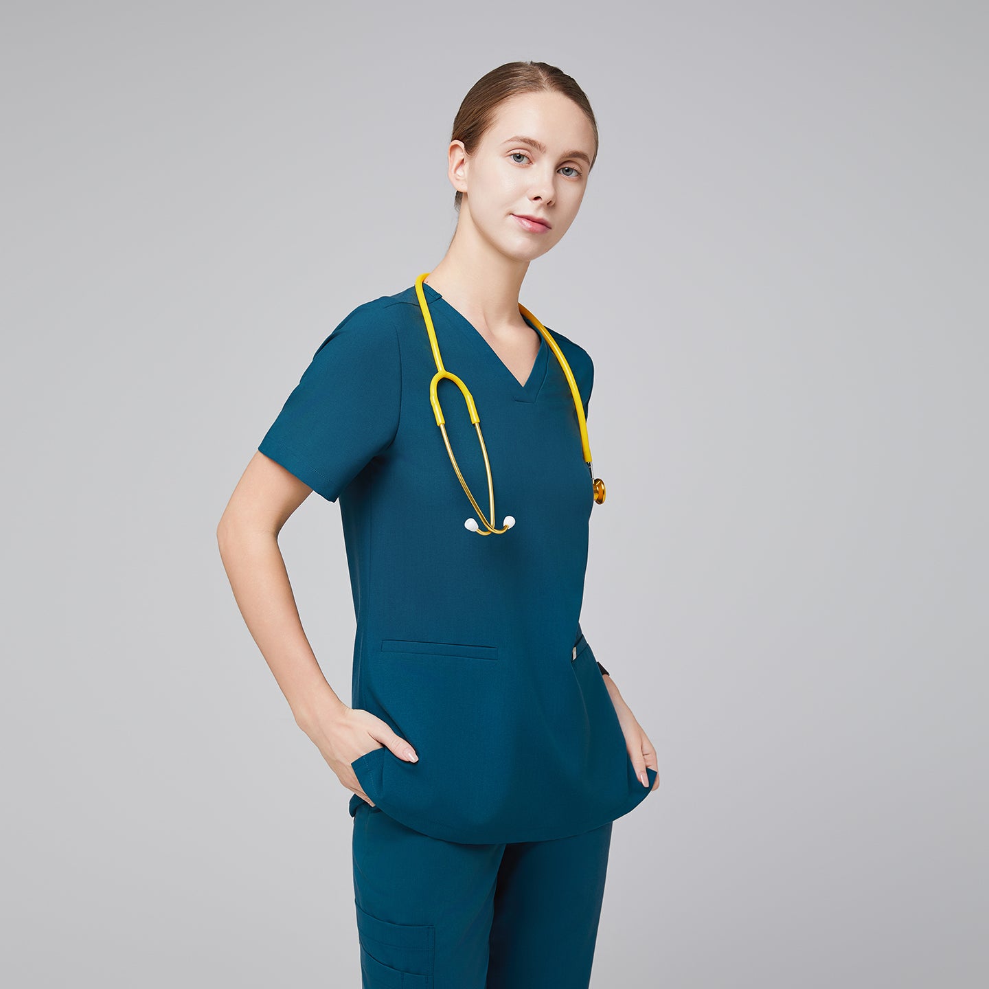 Model in an ocean teal double pocket scrub top with a yellow stethoscope and matching scrub pants,Ocean Teal