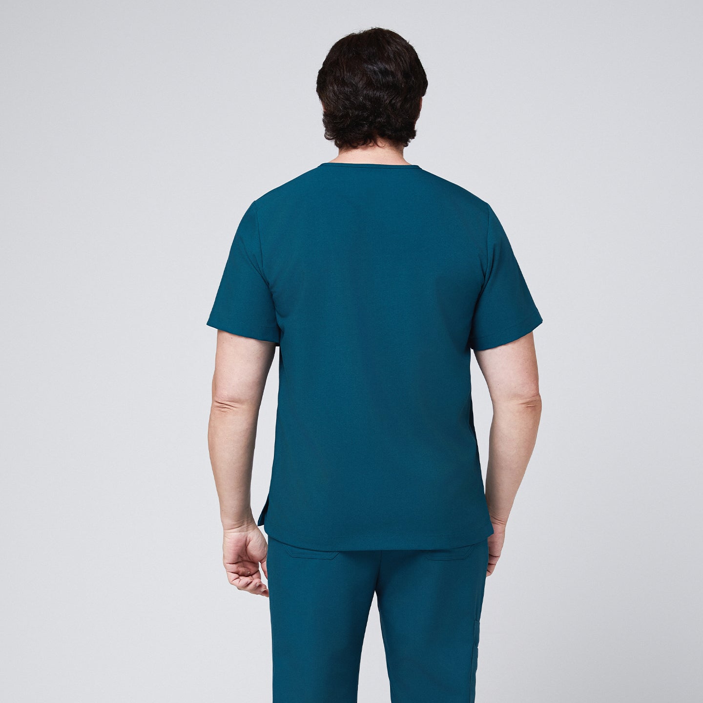 Back view of a man wearing an ocean teal scrub set with a minimalist design,Ocean Teal