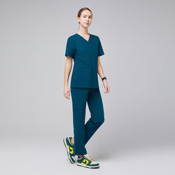 Image of Model wearing ocean teal V-neck scrub top and matching scrub pants with green and yellow sneakers,Ocean Teal