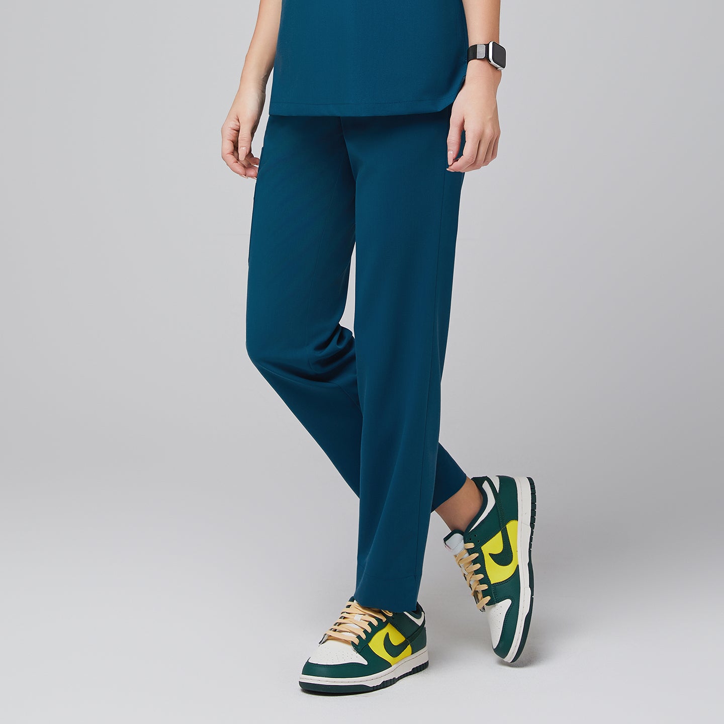 Ocean teal scrub pants with side pocket and split hem, paired with green and yellow sneakers,Ocean Teal