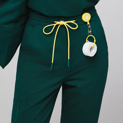 Green scrub pants with yellow drawstring waist and attached medical tape holder,Pine Green