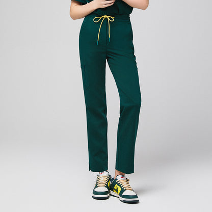 Green scrub pants with zipper pocket and drawstring waist, paired with green and yellow sneakers,Pine Green