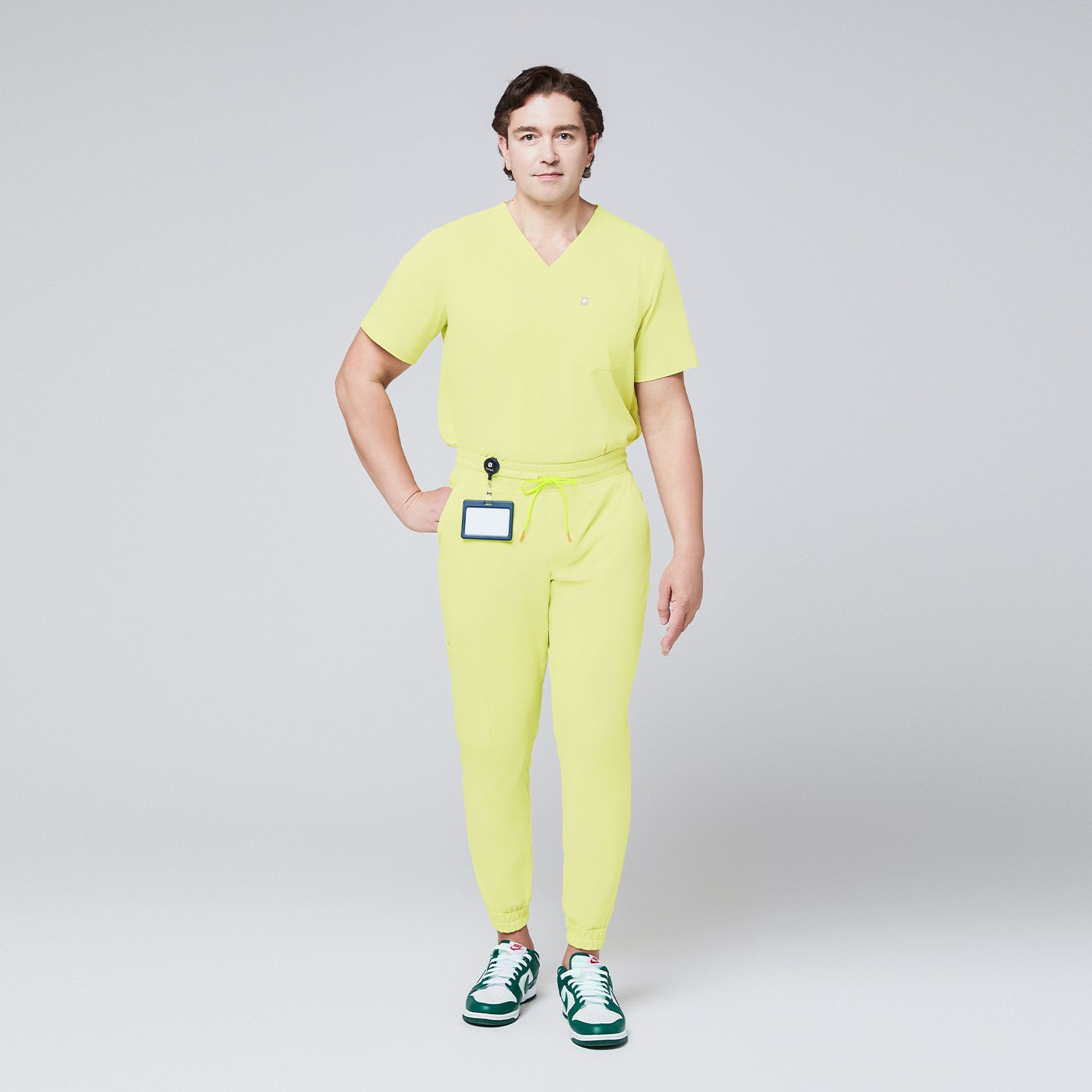 A man wearing a Pineapple Yellow Single Pocket Scrub Top and Pineapple Yellow StretchFit Jogger Scrub Pants, shown in a full-length view,Pineapple Yellow