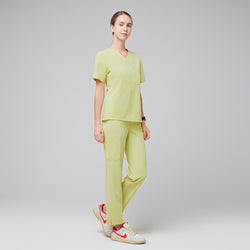 Image of Female healthcare professional in a pineapple yellow scrub set, standing in a relaxed pose with orange-accented sneakers,Pineapple Yellow