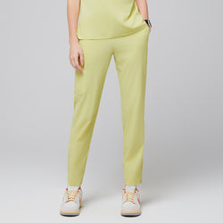 Image of Female wearing pineapple yellow scrub pants with side pocket, paired with beige sneakers,Pineapple Yellow