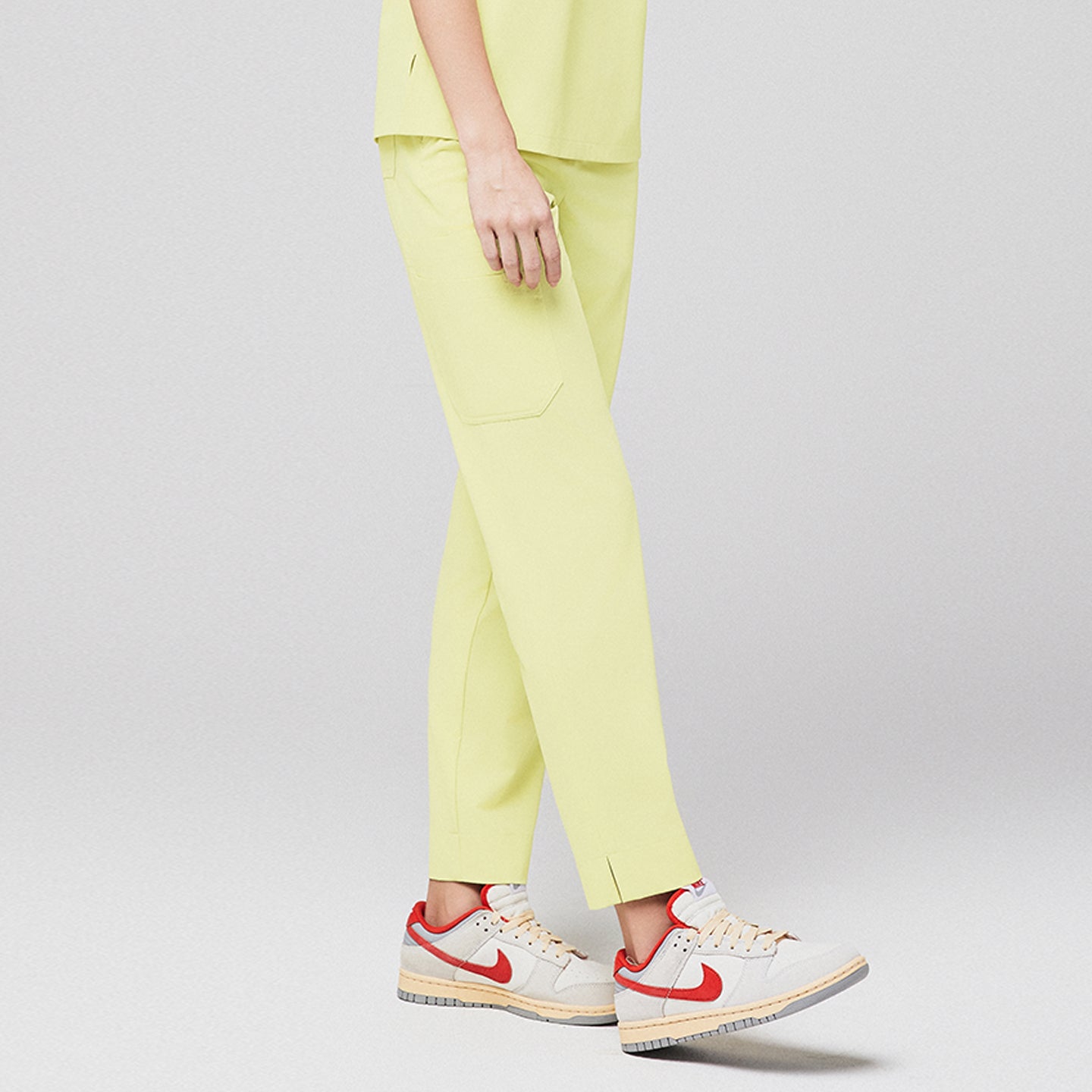 Pineapple yellow scrub pants with split hem and side pocket, paired with gray and red sneakers,Pineapple yellow