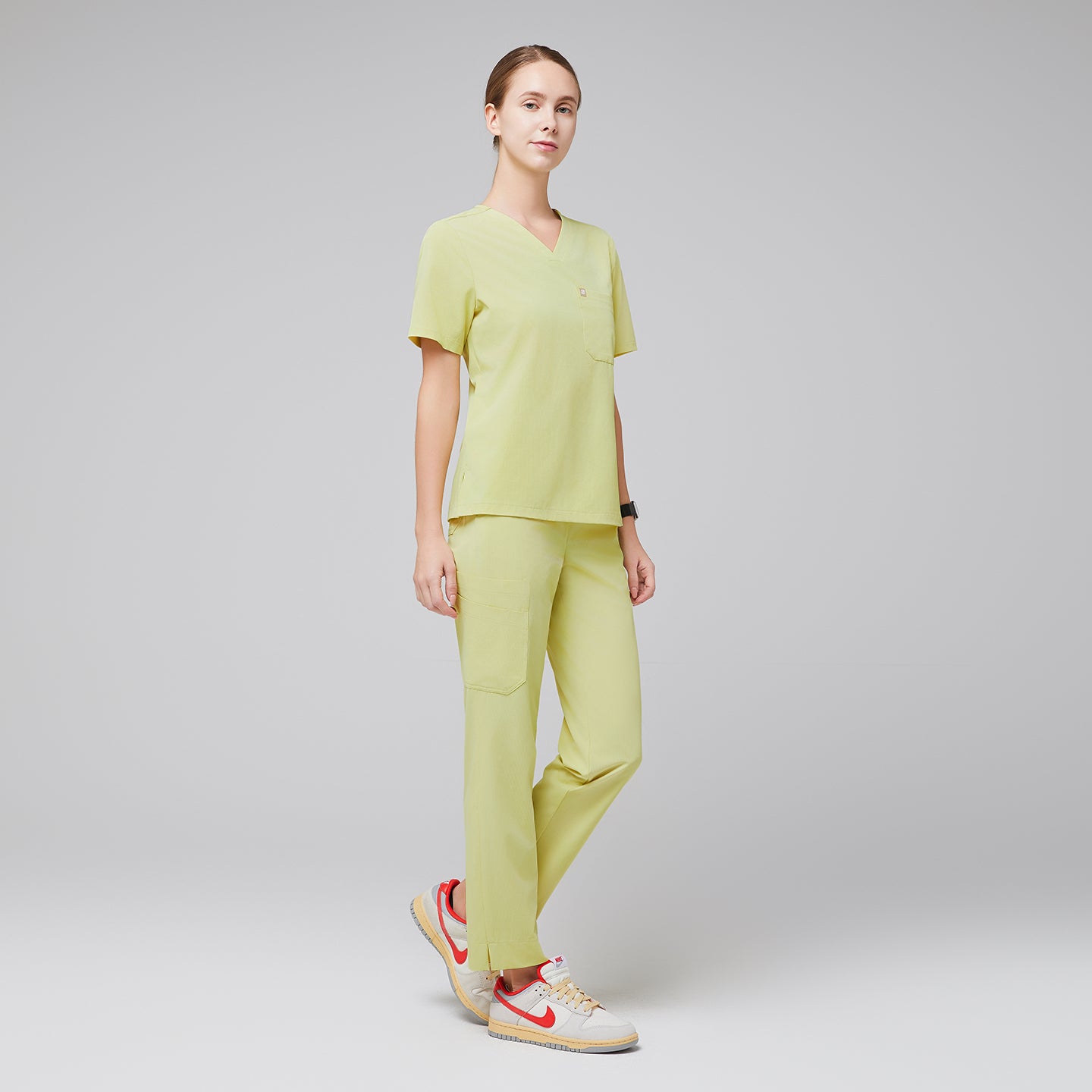 Female wearing pineapple yellow V-neck scrub set with beige and orange sneakers,Pineapple Yellow