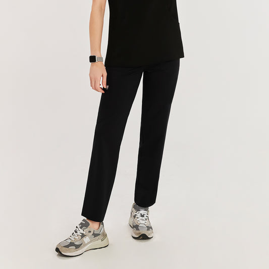 Front view of a woman wearing black zipper slit scrub pants with a side pocket, paired with gray New Balance sneakers,Rich Black