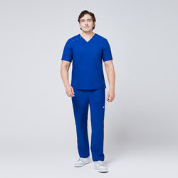 Image of Man wearing Zenir royal blue 3-button scrub set with chest and lower pockets, paired with white sneakers,Royal Blue