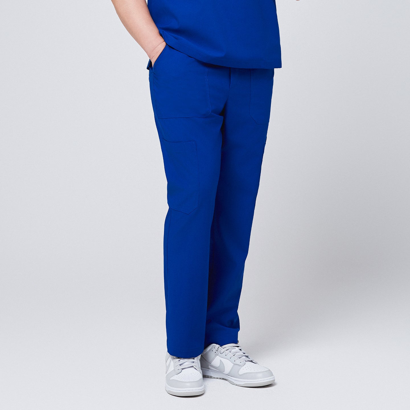 Front view of royal blue 8-pocket straight scrub pants paired with a matching top and white sneakers,Royal Blue