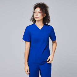 Image of A woman wearing a royal blue scrub top with shoulder button details and matching scrub pants, looking to the side with a confident expression,Royal Blue