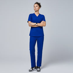 Image of Model wearing a royal blue V-neck scrub set featuring a short-sleeve top and split-hem pants with zipper pockets, paired with black sneakers for a sleek and professional look,Royal Blue