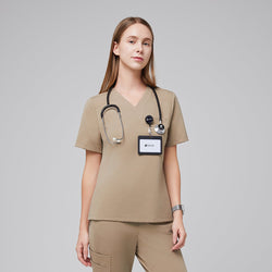 Image of A woman wearing a Sand Beige Pleated Shoulder Scrub Top with an ID badge and stethoscope, paired with matching scrub pants,Sand Beige