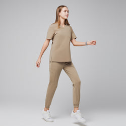 Image of Comfortable scrub set with a V-neck top and jogger pants, shown in a side view during movement, highlighting its practical design,Sand Beige