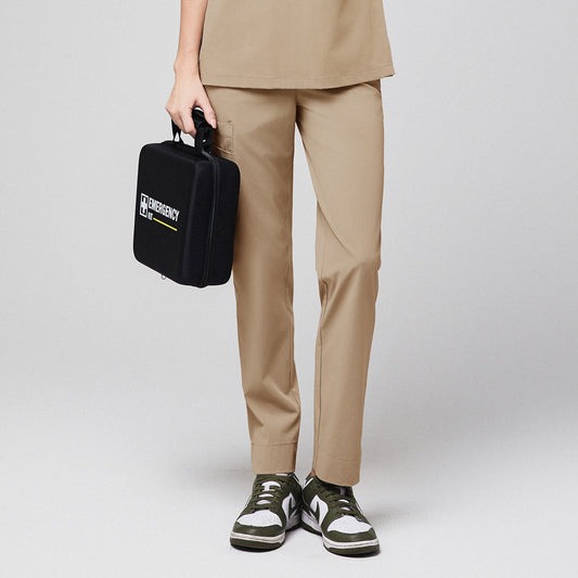 Sand beige scrub pants with split hem and side pocket, holding a black emergency kit, paired with green and white sneakers,Sand Beige