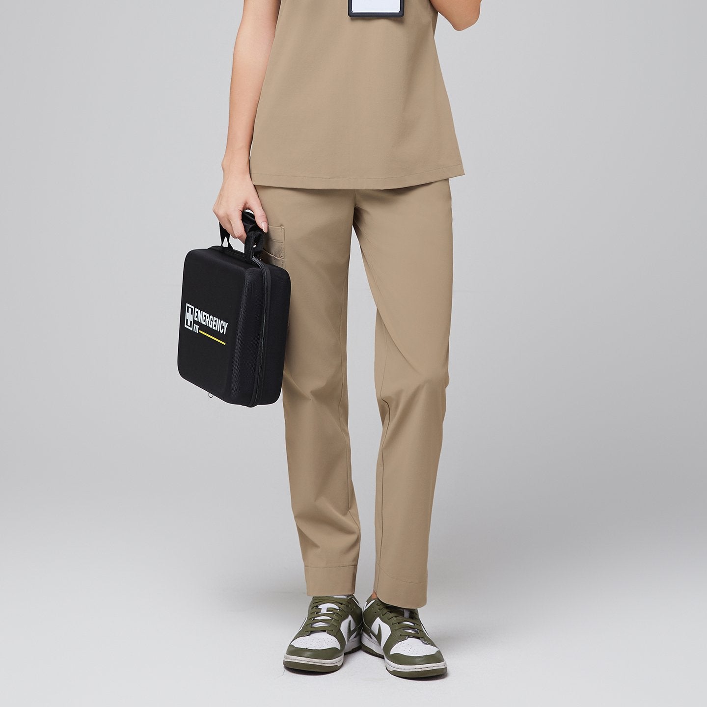 Model wearing the Sand Beige scrub set, holding a black emergency kit, showcasing the comfortable, functional design,Sand Beige