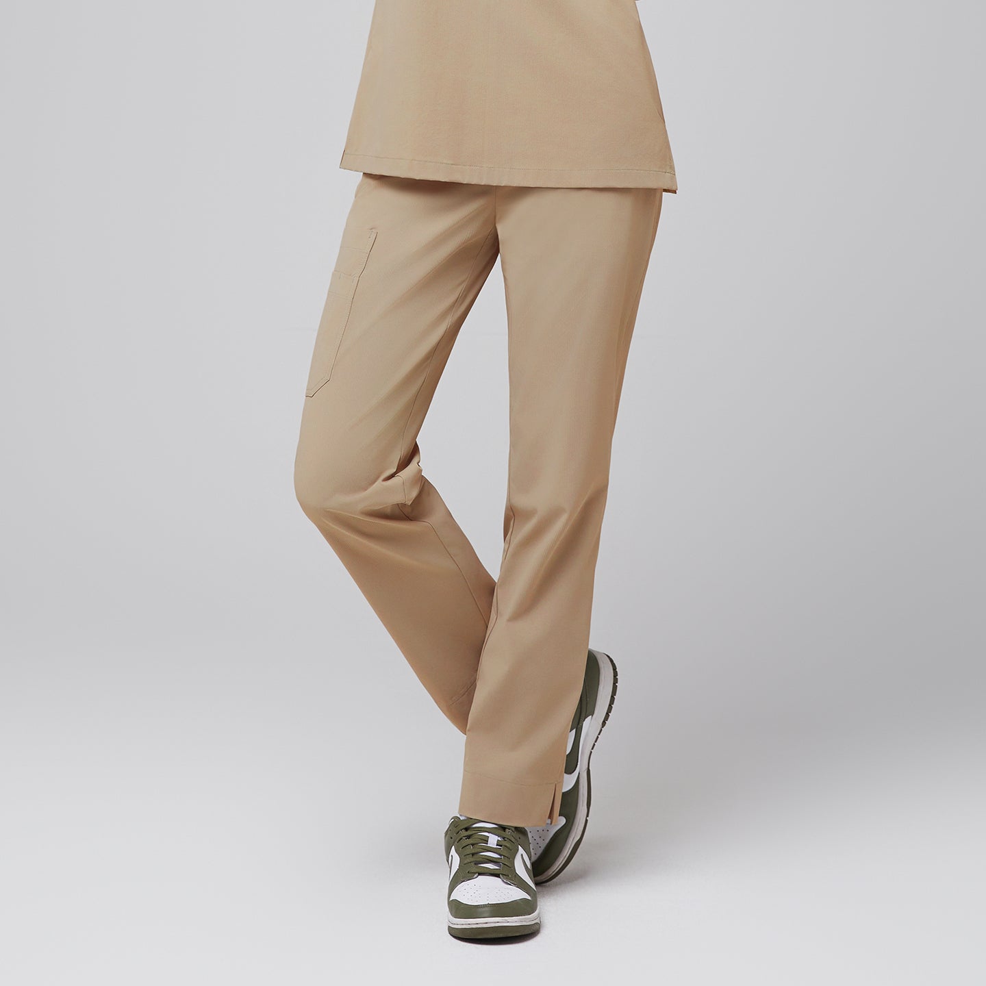 Female wearing sand beige scrub pants, standing with legs crossed, paired with green sneakers,Sand Beige