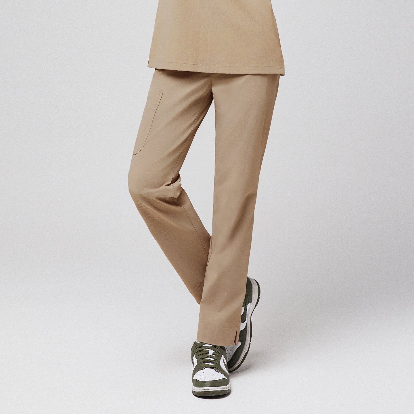 Beige scrub pants with side pocket and split hem, paired with green sneakers,Sand Beige