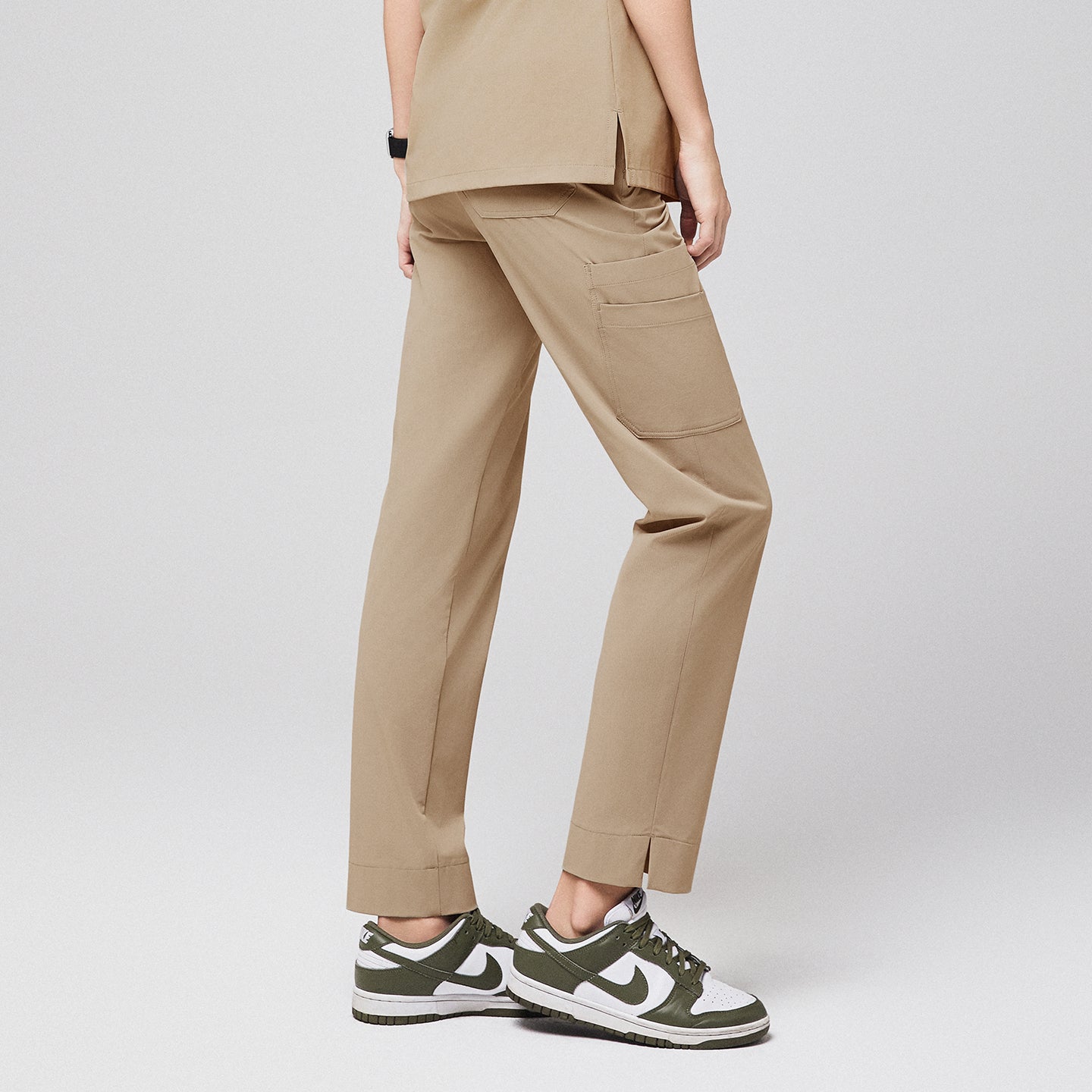 Sand beige scrub pants with split hem and side pocket, paired with green and white sneakers,Sand Beige