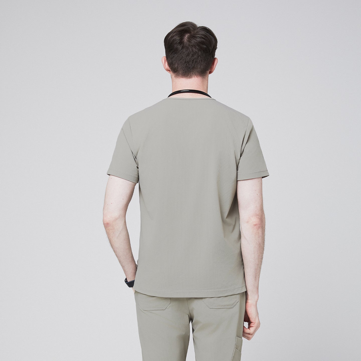 Back view of a male model wearing a sand khaki V-neck single-pocket scrub top,Sand Khaki