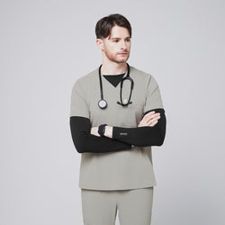 Image of Male model wearing a sand khaki V-neck single-pocket scrub top with a stethoscope and crossed arms,Sand Khaki