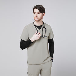 Image of Male model wearing a sand khaki V-neck single-pocket scrub top with a stethoscope around his neck,Sand Khaki