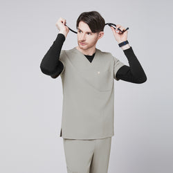 Image of Male model wearing a sand khaki V-neck single-pocket scrub top, adjusting a stethoscope,Sand Khaki