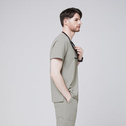 Image of Male model in a sand khaki V-neck single-pocket scrub top, holding a stethoscope, side profile,Sand Khaki