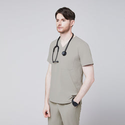 Image of A man wearing a Sand Khaki Single Pocket Scrub Top and matching StretchFit Jogger Scrub Pants, holding a stethoscope at his chest,Sand Khaki