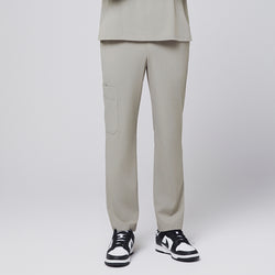 Image of Sand khaki straight-leg scrub pants with a side pocket, paired with black-and-white sneakers,Sand Khaki