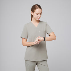 Image of Female healthcare professional in a sand khaki scrub top and pants, checking the time on a smartwatch,Sand Khaki